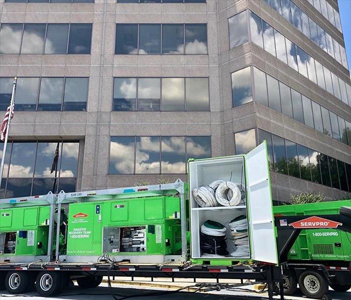 This picture shows a large SERVPRO vehicle fully stocked with equipment in front of a building 