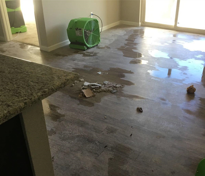 A picture containing water damage inside a home and green dehumidifiers